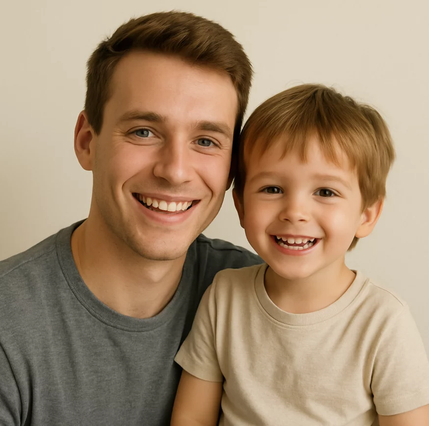 Image of a man and a male child smiling with a plain background